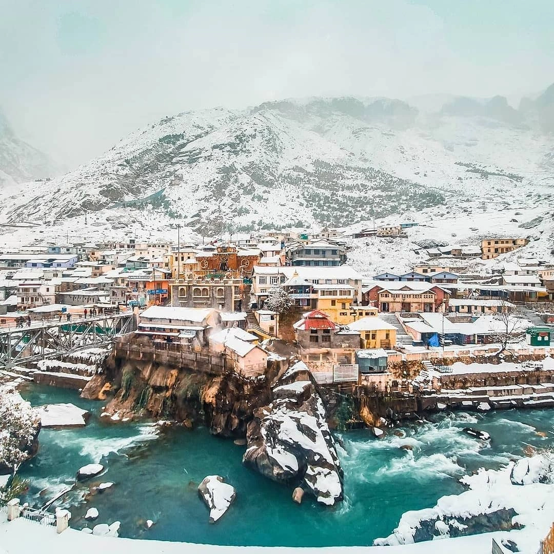 Badrinath Temple covered with snow in Uttarakhand Himalayas with devotees visiting during winter season